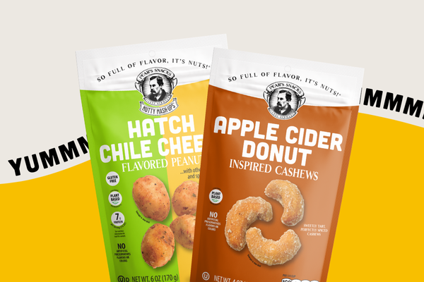 Two packages of flavored nuts - Hatch Chile Cheese & Apple Cider Donut with visible branding on a yellow and white background.